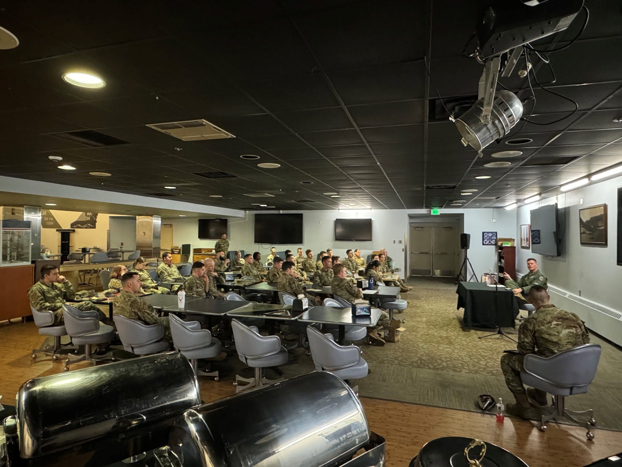 Indoor photo of uniformend service members recieving a briefing.