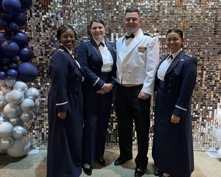 Group photo of uniformed service memebrs in their dress uniforms at a formal event.